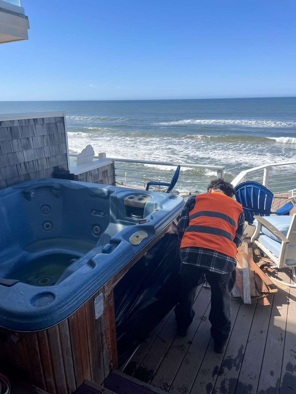 Crew removing a hot tub from an oceanfront deck in San Diego